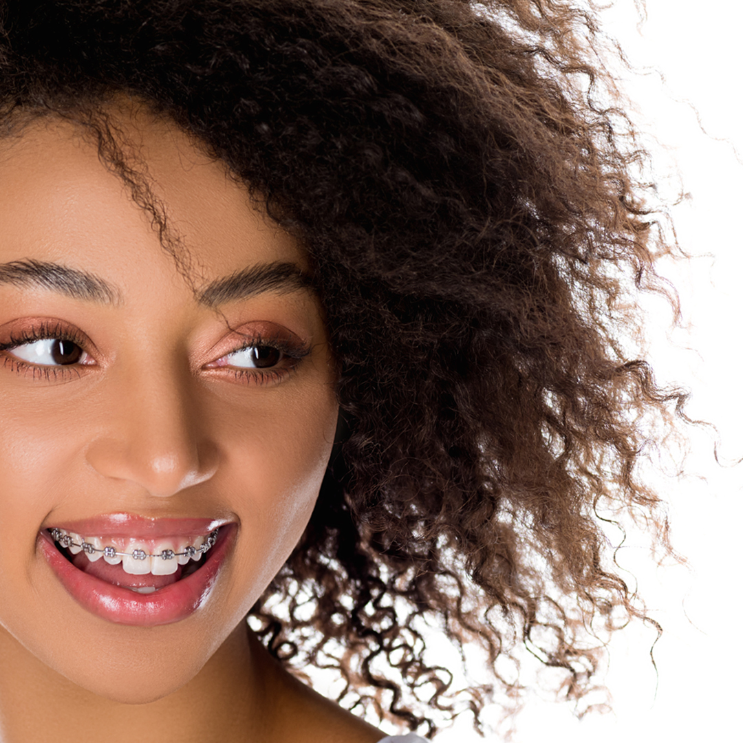 Patient smiling confidently with orthodontic braces